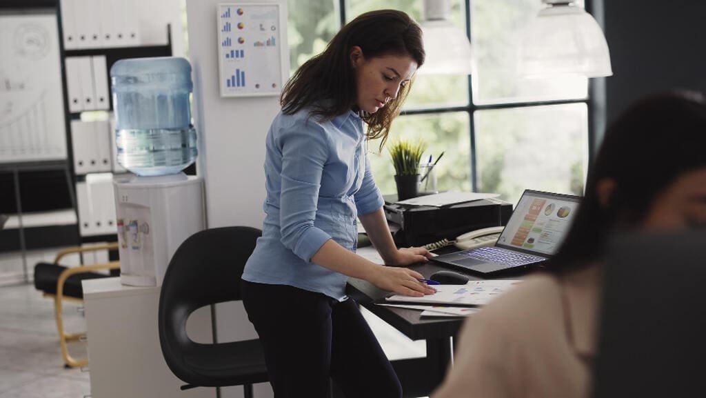 Mujer frente a escritorio en el trabajo revisando notas